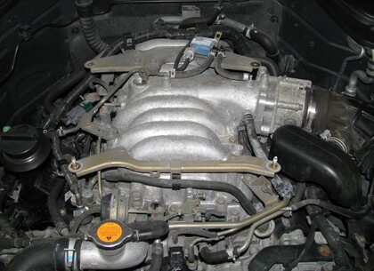 Motorový prostor vozidla po odstranění horního krytu - Velmi brzy po nákupu vozu začal motor klepat s narůstající intenzitou. Reklamaci prodejce neuznal a nový majitel začal řešit problém prostřednictvím znalecké kanceláře.  