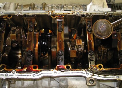 Sejmutí olejové vany ve stojanu bylo dílem okamžiku Na první pohled je viditelná přítomnost zbytků ložiskové kompozice v sacím koši a tmavé zabarvení ojnic pátého a šestého válce (druhý ojniční čep z levé strany bloku motoru).  